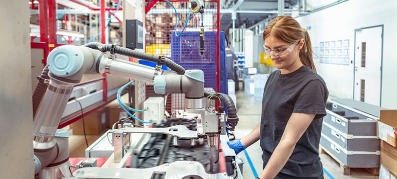 Worker working with cobot, robot assembly machine in automotive parts factory 