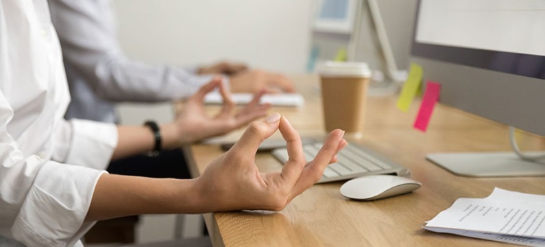 Office yoga for relaxation or concentration concept, calm businesswoman meditating at work, peaceful mindful employee practicing exercises at workplace, focus on female hands in mudra, close up view