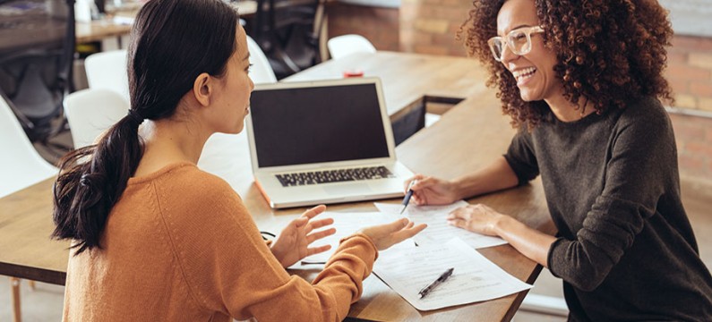 Asian and Black young professionals having a meeting at a desk