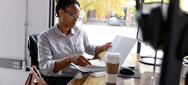 Black young female professional working on laptop from a coffee shop