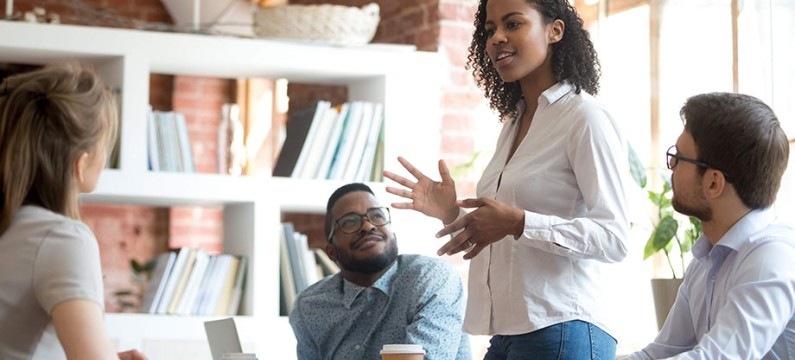 Black young female professional leading a meeting with colleagues