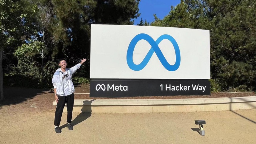 Xiangjian Zhang standing in front of Meta sign