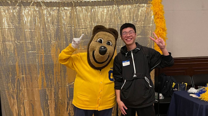 Xiangjian Zhang standing with Oski mascot