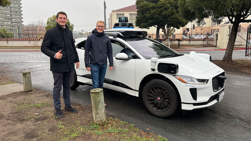 Sebastian Sartor and friend standing in front of an EV car