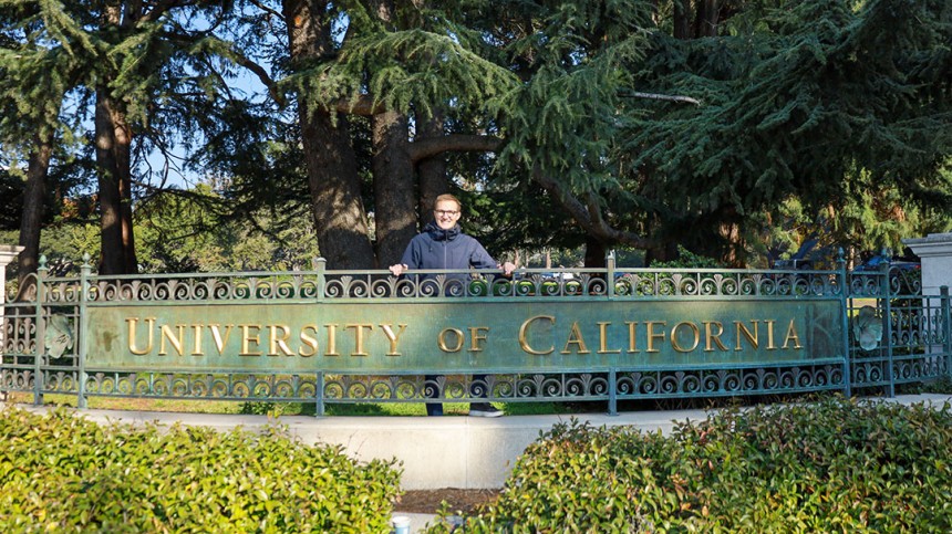 Sebastian Sartor standing behind University of California sign