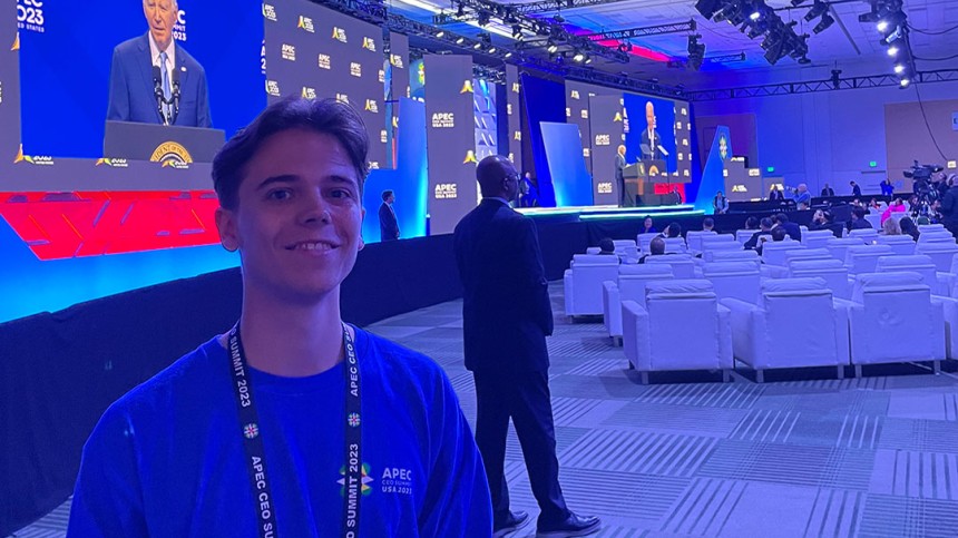 Wesley de Vries attends a conference with President Biden on screen behind him