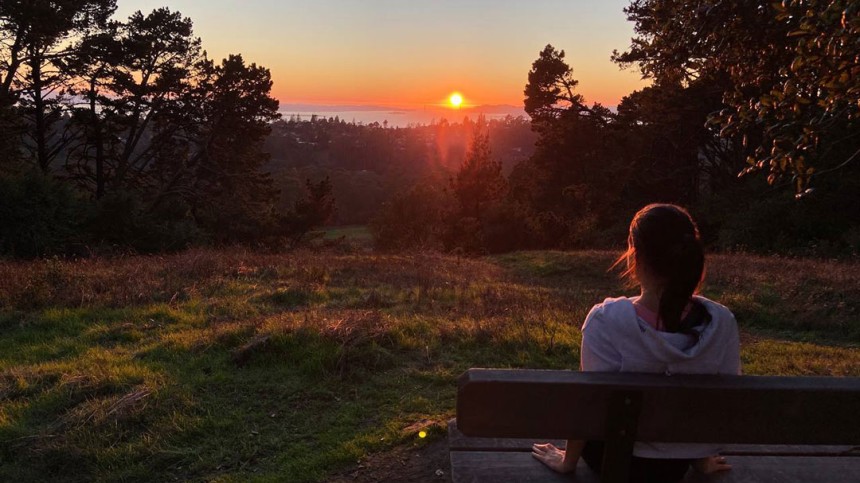 Aliona Margulis sits on a bench watching the sun set