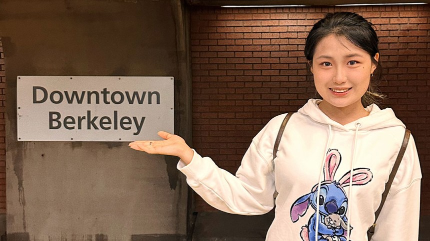 Nancy Jiayi Hou posing in front of BART Downtown Berkeley sign